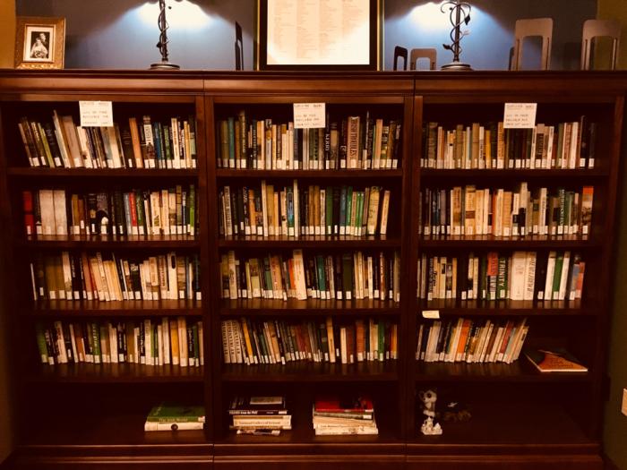 Three shelves of books on wooden shelves.